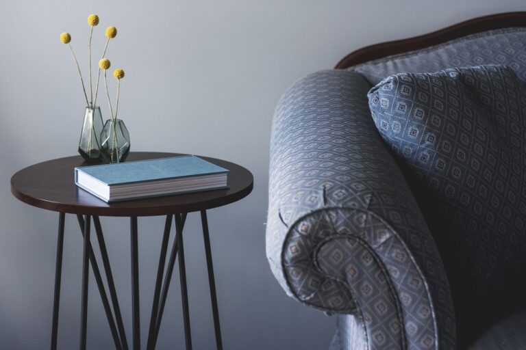 Setting for a mental health therapy session. A side stool, a book, a miniature table decoration and a sofa. Lets Talk